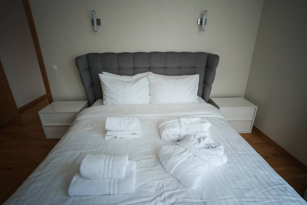 istock Fresh white fabric linen lying on double bed inside of hotel room. 1440353308