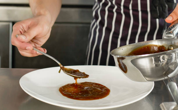 istock Chef prepaing a dish with gravy sauce 1440355136