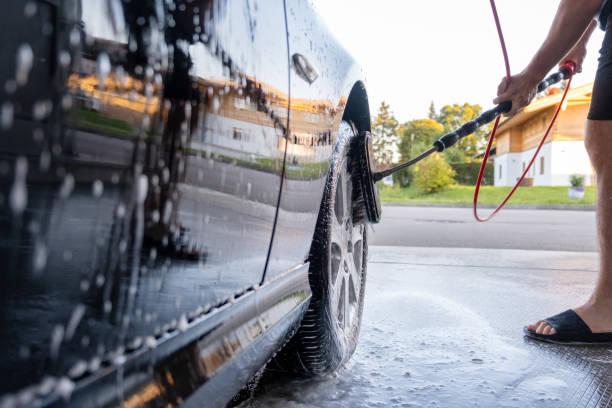 istock Washing a black car with active foam. Wheel cleaning. 1440360286
