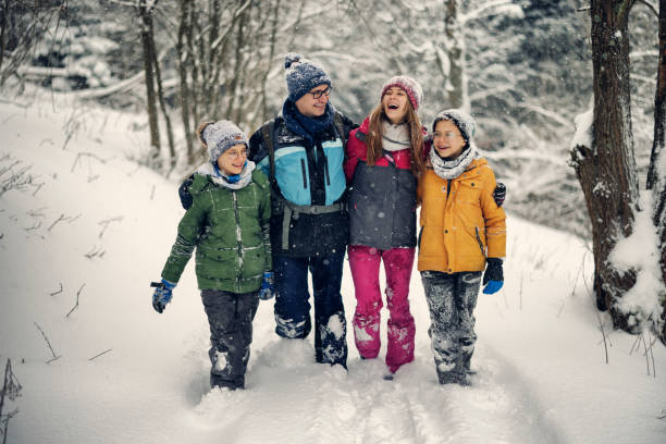 père en randonnée avec des adolescents dans une belle forêt d’hiver. - group of people teenager snow winter photos et images de collection