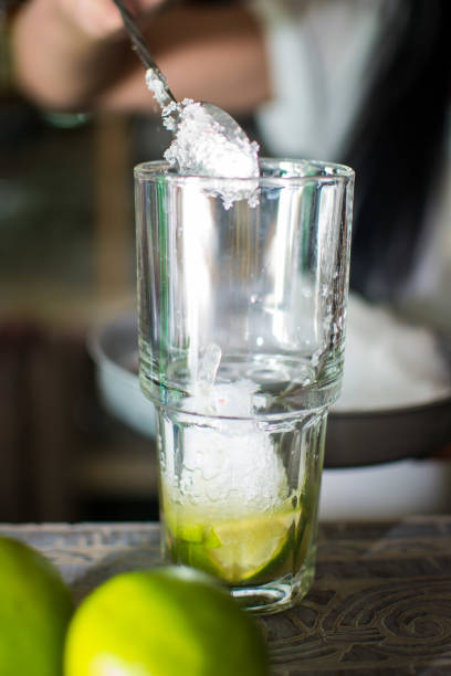 istock Bartender making refreshing coctail on a bar background. Dark moody style. Ice in tha glass 1440362701