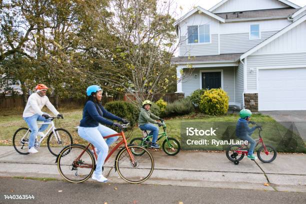 Family Riding Bicycles On Neighborhood Street Stock Photo - Download Image Now - Community, Residential District, Family