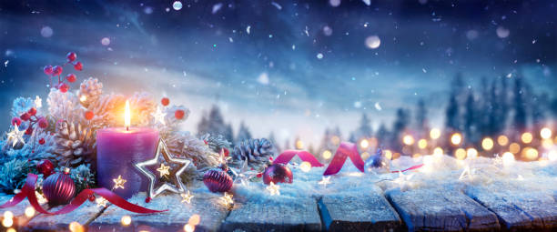 Advent Candle With Christmas Decoration On Snow Table - Defocused Landscape With Snowfall