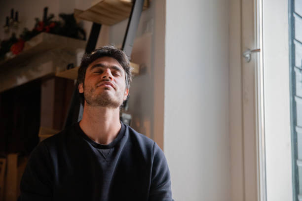 istock Young man in meditation sitting with eyes closed and head bended backward 1440366733