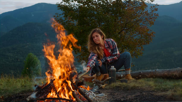 istock Thoughtful hipster travel camping spend vacation in mountains campfire nature. 1440367158