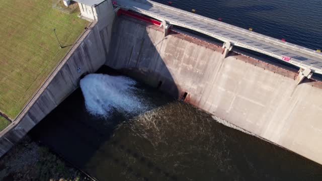 Concrete dam and walkway over hydropower and water plant from high angle view