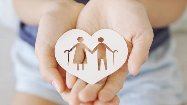 Hands holding diversity family, happpy carer and volunteer, disable nursing home, rehabilitation and health insurance concept kid hands holding elderly couple with walking sticks in heart shape, older people mental health, age care concept aging population stock pictures, royalty-free photos & images