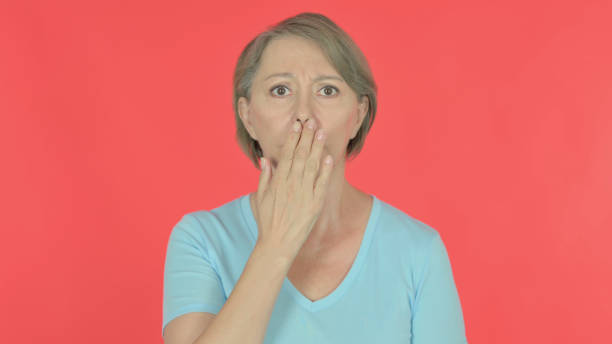istock Shocked Old Woman on Red Background 1440378220
