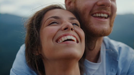 Portrait of cheerful family having fun outdoor. Closeup happy couple faces laughing outside. Joyful man and woman spending summer holiday honeymoon together in mountains. Joy happiness concept.