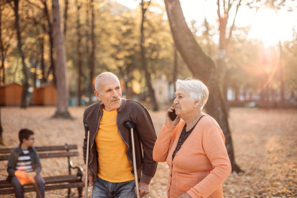 Old people with disabilities walking in public park stock photo