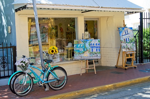 Colorful aqua bicycles parked in front of art studio in Key West Florida, May 2019. Just on of the many corner art studios in this south Florida keys tourist destination.