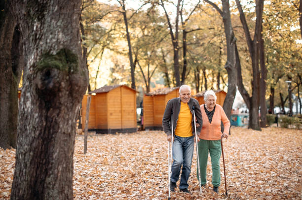 istock Old people with disabilities walking in public park 1440380330