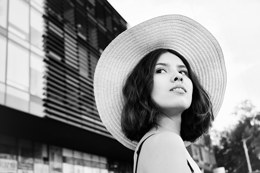 young attractive woman in hat at city closeup portrait, monochrome