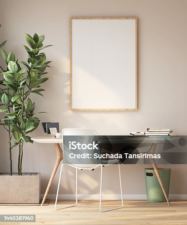 istock Large blank wooden picture frame with mat on cream colored wall in modern, luxury and cozy room with working desk, chair and fiddle leaf fig tree on parquet floor 1440381960