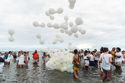 Santo Amaro, Bahia, Brazil - May 15, 2022: People releasing air balloons on the beach during the Candomble religious demonstration called Bembe do Mercado in the city of Santo Amaro.