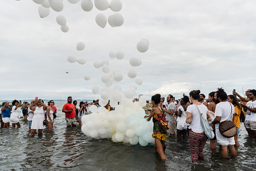 Santo Amaro, Bahia, Brazil - May 15, 2022: People releasing air balloons on the beach during the Candomble religious demonstration called Bembe do Mercado in the city of Santo Amaro.