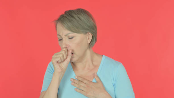 istock Old Woman Coughing on Red Background 1440388896