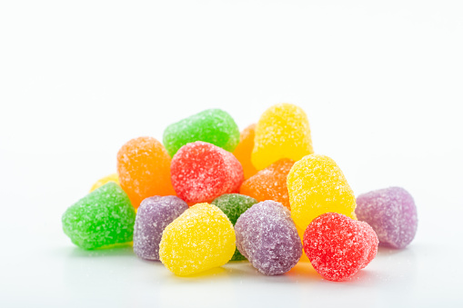 Colorful gum drops in a heap on a white background