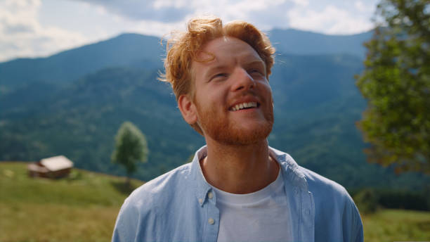 istock Young man bearded face looking around enjoying mountains landscape close up. 1440391674