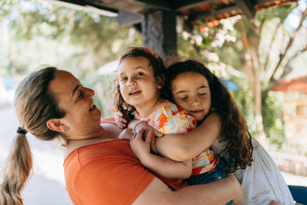 istock Mother and daughters hugging each other 1440397563