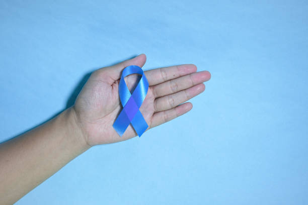 istock Top view blue ribbon awareness with red blood drop in man hands 1440398675