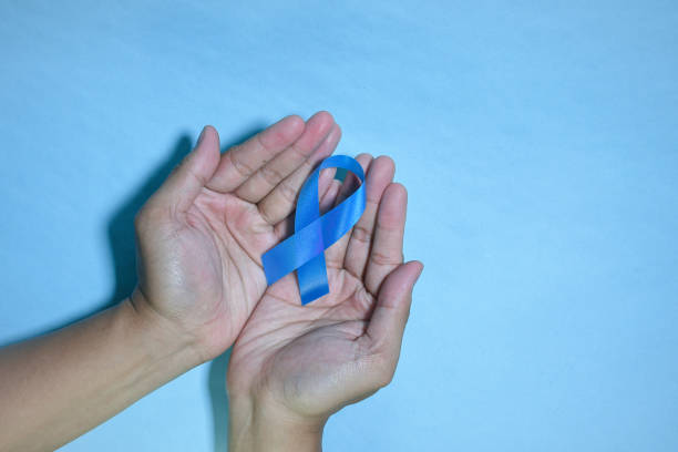 istock Top view blue ribbon awareness with red blood drop in man hands 1440398705