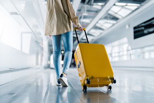 Terminal del aeropuerto internacional. Hermosa mujer asiática con equipaje y caminando en el aeropuerto photo