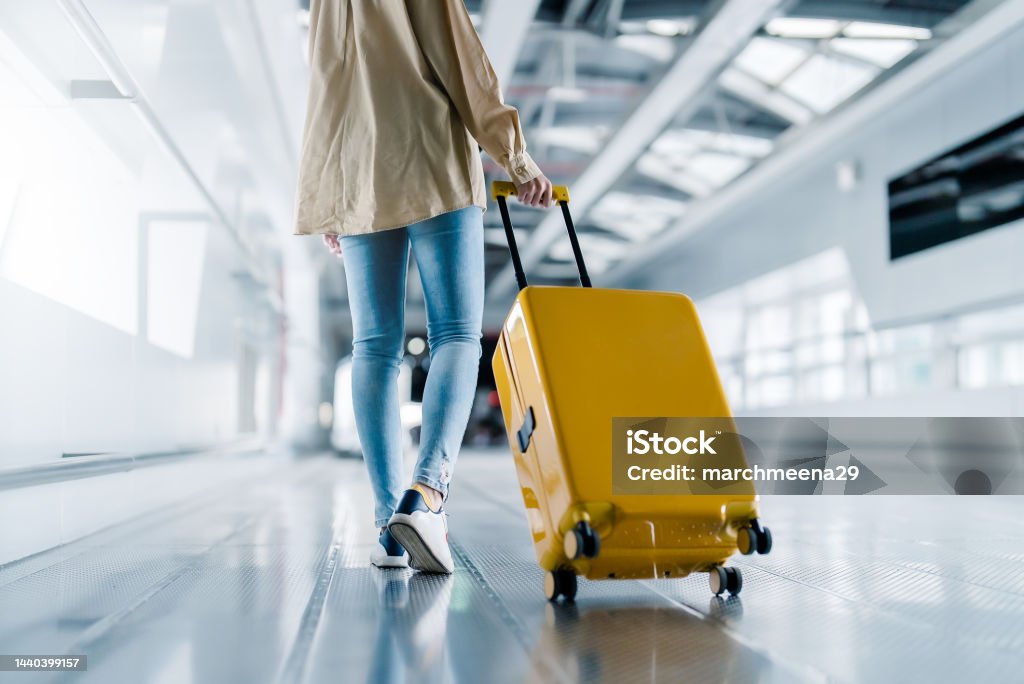 International airport terminal. Asian beautiful woman with luggage and walking in airport Travel Stock Photo