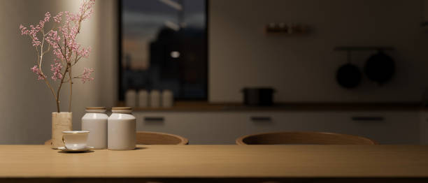 istock Modern wood dining table with copy space over blurred dark kitchen in background. 1440400295