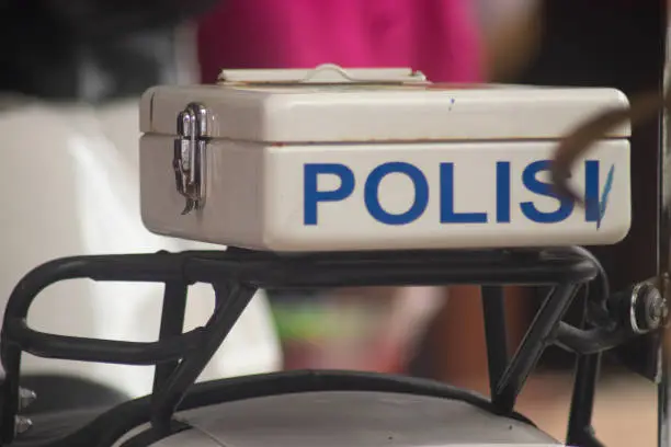 Photo of Indonesian police motorbike close up on police inscription (Indonesian)