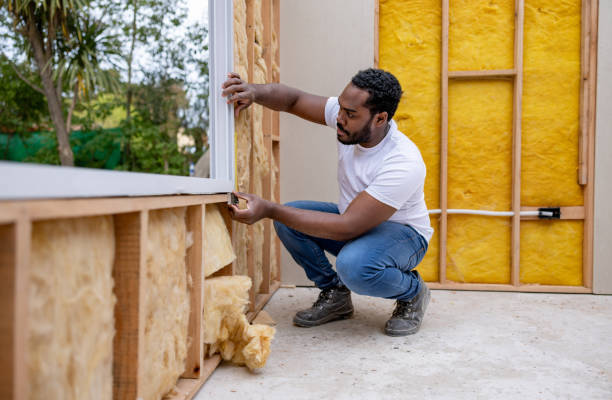 Man installing a window while working as a volunteer building a house