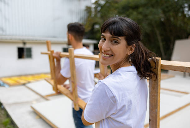 Happy volunteer carrying construction materials while building a house