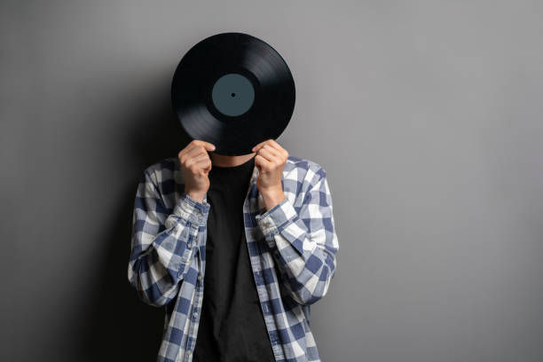 istock holding a vinyl record disc in front of head 1440405825