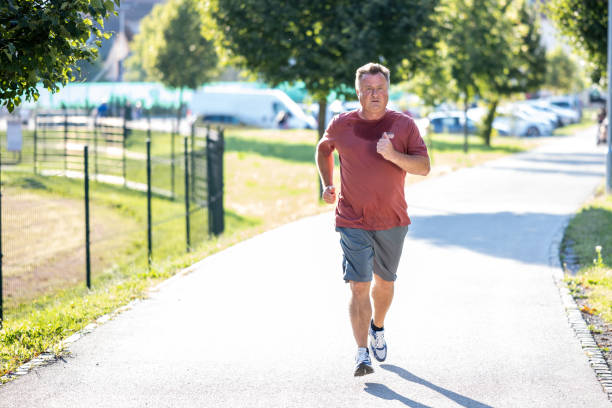 istock Mid adult man jogging in road, endurance 1440409325