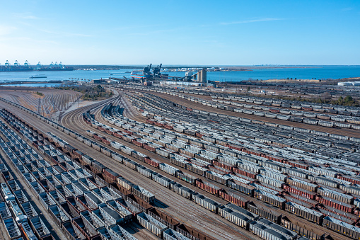 Aerial view of a train yard near the river with many rail cars