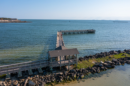Aerial view of a wooden Pier coming off of a rock jetty in Cape Charles Virginia