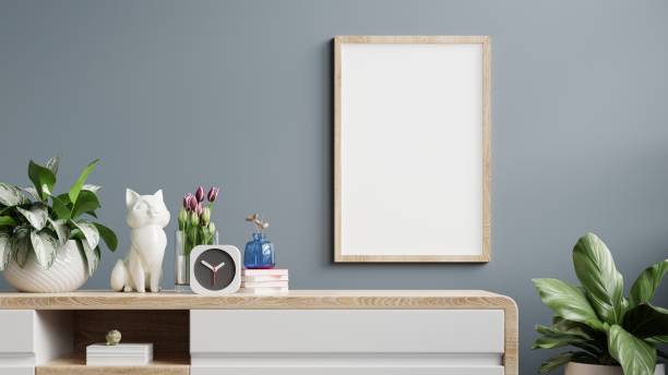 Mockup frame on cabinet in living room interior on empty dark blue wall background.