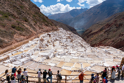 Cuzco, Peru - August 14, 2022: tourists contemplating the salt mine in Cusco