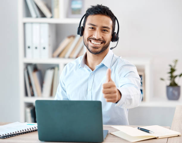 istock Thumbs up, customer service and call center with a man saying yes while working in telemarketing and sales. Motivation, crm and contact us with a male employee saying thank you while consulting 1440426801