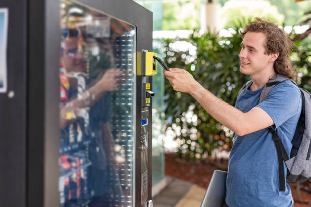 personne effectuant un paiement numérique à un distributeur automatique - vending machine photos et images de collection