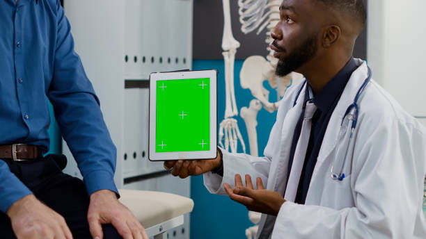 istock Doctor and elderly patient looking at greenscreen display 1440436417