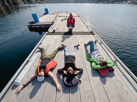 Adult 2 generation family enjoying leisure time on a sunny secluded dock surrounded by an ocean inlet in Bamfield, Vancouver Island, British Columbia, Canada.