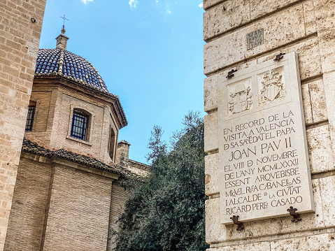 Valencia, Spain - September 19, 2020: Commemorative marble plaque hanging from stone wall. It remembers the visit of Pope John Paul II to the city of Valencia in the year 1982