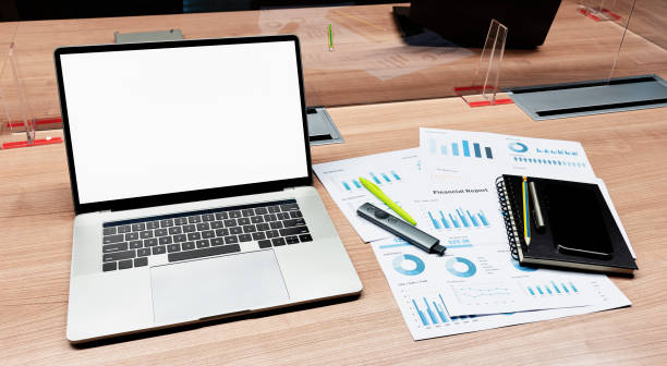 White screen on display laptop and paperwork on table in meeting room