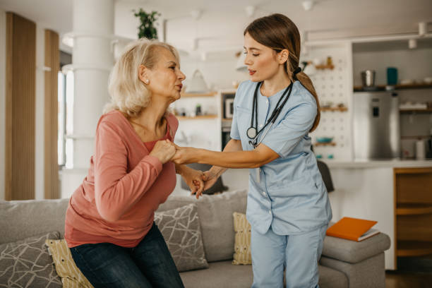 istock Nurse helping patient to stand up 1440442376