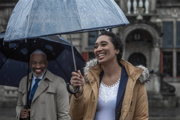 Two multi ethnic traveller colleagues commuting together in Delft on a rainy day