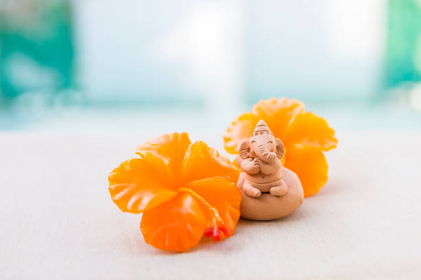 istock Ganesh clay sculpture with hibiscus candle flower 1440444090