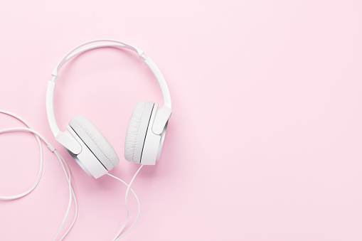 Headphones on pink background. Flat lay with copy space
