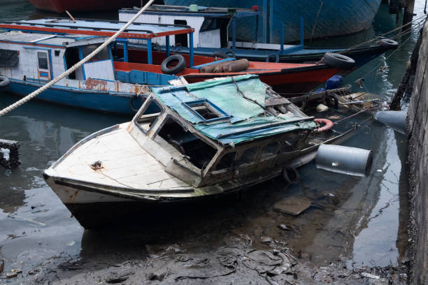 selective focus on fishing boats that sank on the beach, damaged ships became trash at sea