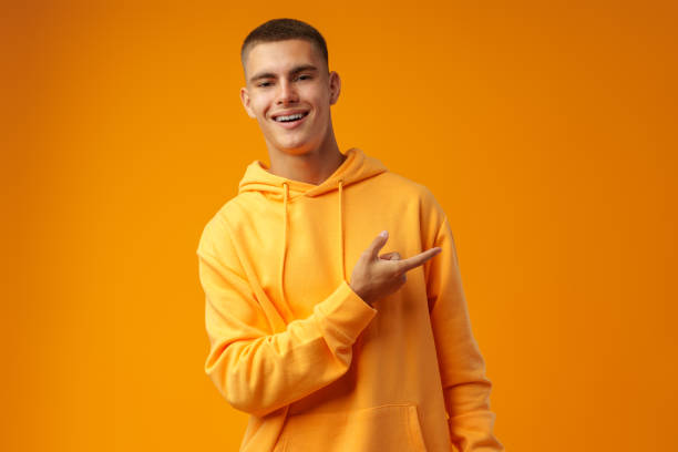 istock Handsome young man pointing to copy space on a yellow background 1440448299